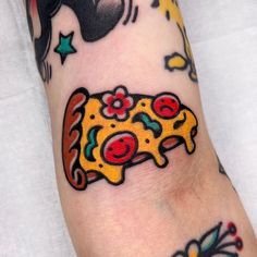 a person with tattoos on their arm has a yellow piece of food in the shape of a car