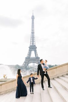 a family poses for a photo in front of the eiffel tower