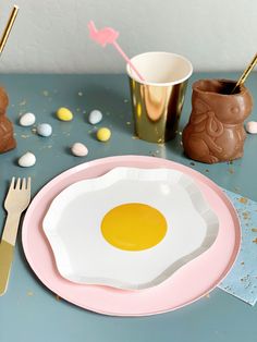 a plate with an egg on it next to other plates and utensils,