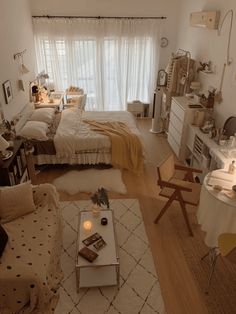 a living room filled with furniture next to a window covered in white drapes and curtains