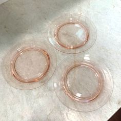 three clear glass plates sitting on top of a marble counter next to a white wall