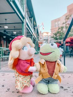 two stuffed animals that are sitting on the ground