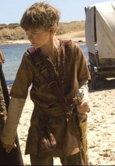 two young boys dressed in medieval clothing on the beach