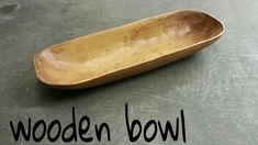 a wooden bowl sitting on top of a cement floor next to the words wooden bowl