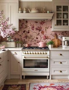 a white stove top oven sitting inside of a kitchen next to a counter with flowers on it