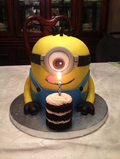 a birthday cake with a candle in the shape of a minion