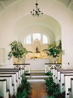 the interior of a church decorated with greenery and candles