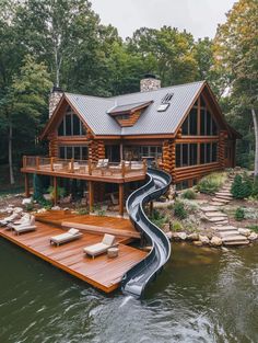 a house that has a slide going down the side of it in front of some water