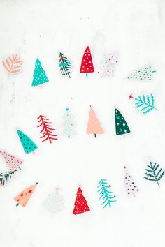 a group of paper christmas trees sitting on top of a white surface