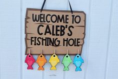 a sign that says welcome to caleb's fishing hole hanging on the side of a building