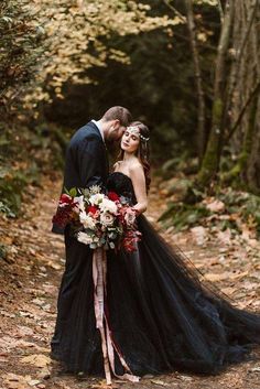 a bride and groom are standing in the woods with their wedding bouquets wrapped around them