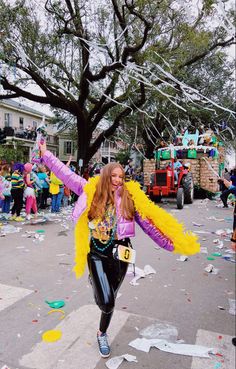 a woman is running down the street with her arms in the air as confetti falls around her