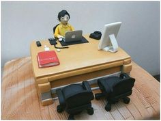 a cake made to look like an office desk with a laptop and chair on it