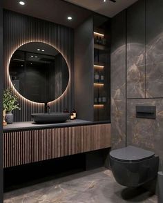 a black and gold bathroom with a round mirror on the wall above the toilet seat