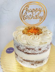 a birthday cake with frosting and a happy birthday sign on top is sitting on a gold plate