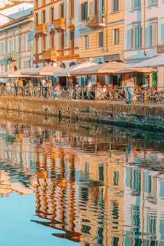 people are sitting at tables along the river bank stock photo