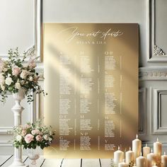 a wedding seating chart with candles and flowers