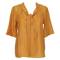 GUARANTEED AUTHENTIC CHLOE FALL 2007 MARIGOLD SILK BLEND SHORT SLEEVE BLOUSE Design: - Short sleeve marigold (yellow-orange) silk blend blouse. - Scoop neck, with tie accent. - Buttons down back of blouse. - Beautiful, lightweight year round. Size: 36 Material: 75% Silk, 25% Wool Measurements (Approximate laid flat): - Shoulder to Shoulder: 15" - Underarm to Underarm: 18" - Sleeve Length: 12.25" - Total Length: 23" (tip of rear neckline to bottom front center hem) To Our Customers: -We consider Luxury Yellow Silk Blouse, Luxury Yellow Dola Silk Blouse, Luxury Yellow Cotton Silk Blouse, Luxury Yellow Short Sleeve Blouse, Short Sleeve Blouse Design, Black Silk Blouse, Marigold Yellow, Black Cami Top, Blouse Designs Silk