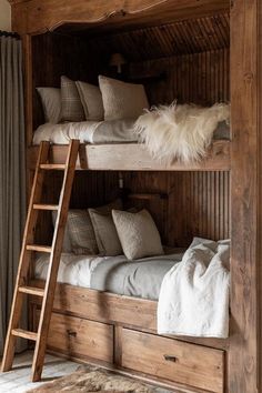 a wooden bunk bed with two ladders and pillows on top of it, next to a window