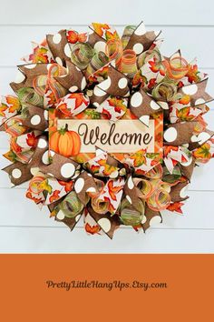 a welcome fall wreath made out of burlocks and paper pumpkins with the words,