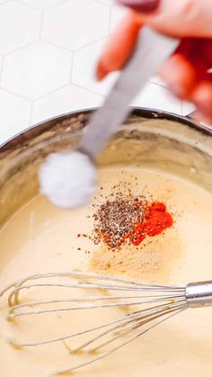 a person whisking spices in a saucepan