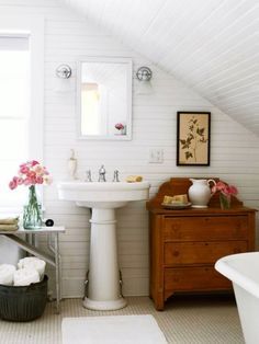 a bathroom with a sink, toilet and bathtub in it's attic space