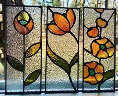 three stained glass panels with flowers on them