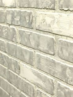 a brick wall that has been painted white and is being used as a background or backdrop