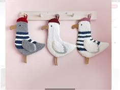 three knitted birds hanging on a wall