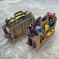 two wooden crates filled with tools on top of a cement floor next to each other