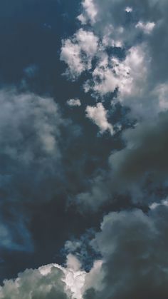 an airplane is flying through the cloudy sky