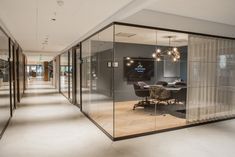 an office with glass walls and chairs in the middle is shown from the hallway to the dining room