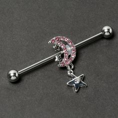 Product Details14 Gauge Pink CZ Gem Moon Dangle Star Industrial Barbell 38mm Give your industrial piercing a look as lovely as the night sky with this 14 gauge helix barbell. It is made with a 1 1/2 inch 316L surgical grade stainless steel straight barbell with 5mm ball ends. It features a crescent moon charm, embellished along the edge with pink cubic zirconia gems and tiny stars. Dangling beneath is another star with a clear cubic zirconia gem at the center. You can even slide it up and down t Piercing Inspo, Industrial Barbell, Industrial Piercing, Tiny Star, Moon Charm, Helix, Crescent Moon, Night Sky, Crescent