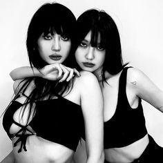 two women in black bathing suits posing for the camera