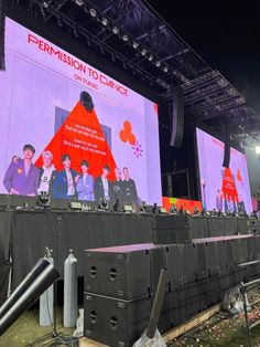 the stage is set up for an event with people standing on it and two large screens