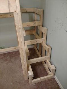 a room with several wooden shelves in the corner and one on the floor next to it