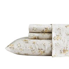 the sheet set is white with yellow flowers on it and has four pillows in front