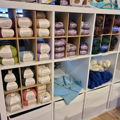 the shelves are filled with different types of yarn