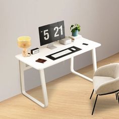 a computer desk with a chair next to it and a clock on the wall behind it