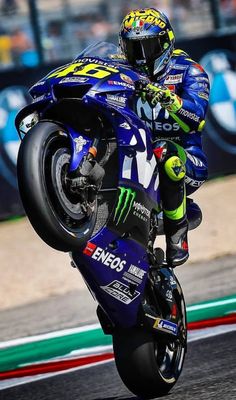 a man riding on the back of a blue motorcycle