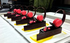 four desserts are arranged on top of each other in the middle of a table