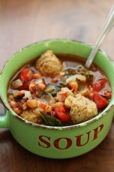 a green bowl filled with soup on top of a wooden table