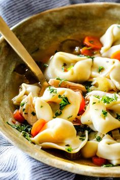 a bowl filled with pasta and vegetables on top of a table