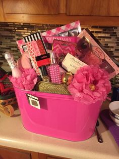 a pink basket filled with lots of items on top of a counter