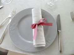 a white plate with a pink ribbon on it