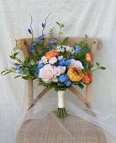 a bouquet of flowers sitting on top of a wooden chair