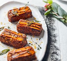 four pieces of meat on a plate with herbs and seasoning sprinkles