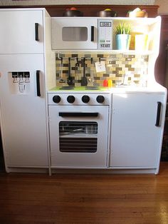 a white stove top oven sitting inside of a kitchen