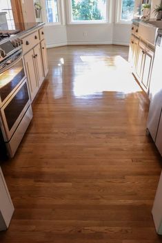 a kitchen with hardwood floors and white cabinets