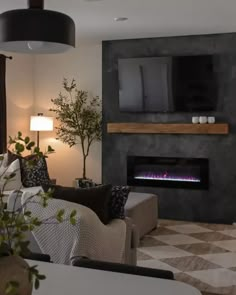 a living room filled with furniture and a flat screen tv mounted on the wall above a fire place